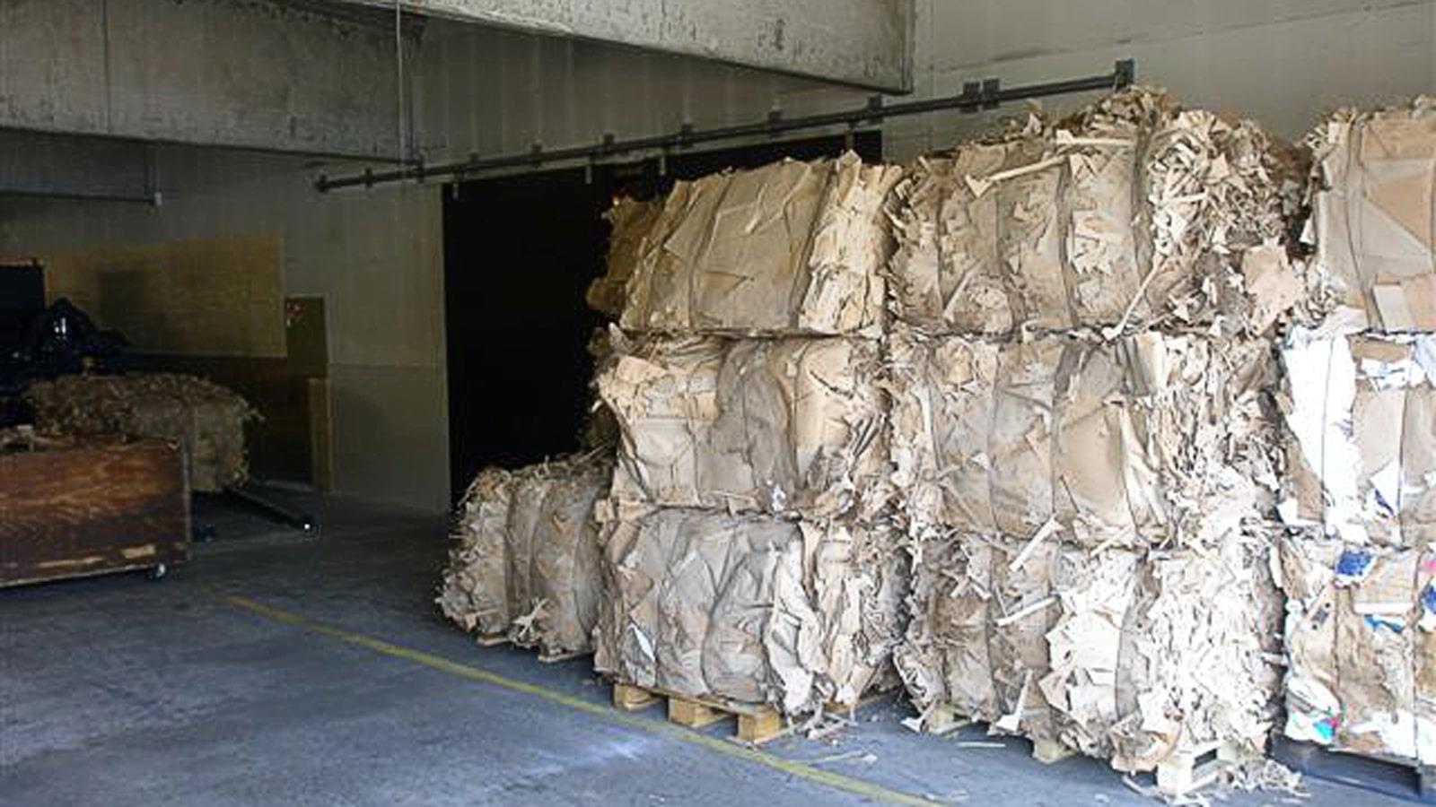Bales of cut cardboard stacked in storage room