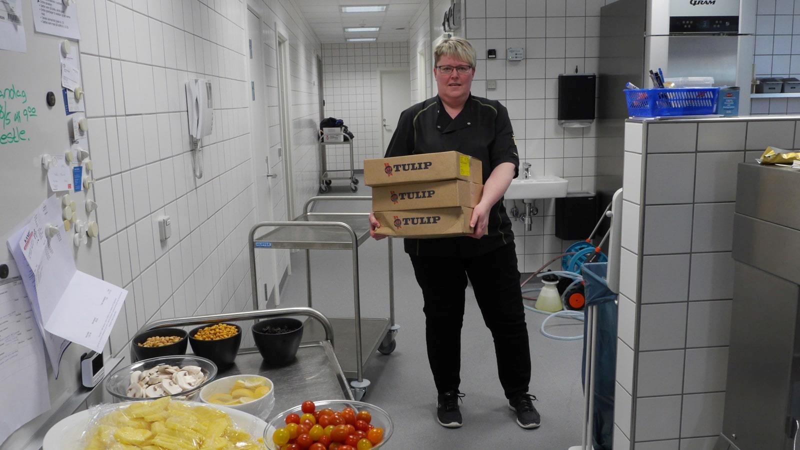 Canteen employee carrying boxes with Tulip meat products